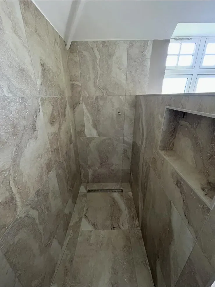 Grey large-format wet room by Prestige Tiling